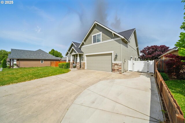 craftsman inspired home featuring a garage, a front yard, stone siding, a gate, and driveway
