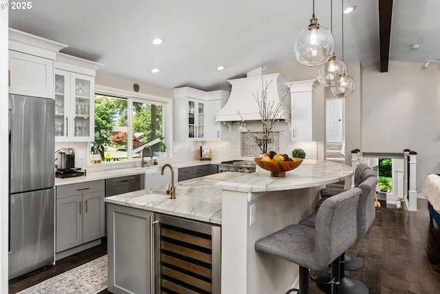 885 NW Torrey View Ln, Portland, OR 97229 - kitchen featuring stainless steel appliances, wine cooler, gray cabinets, custom range hood, and a center island with sink