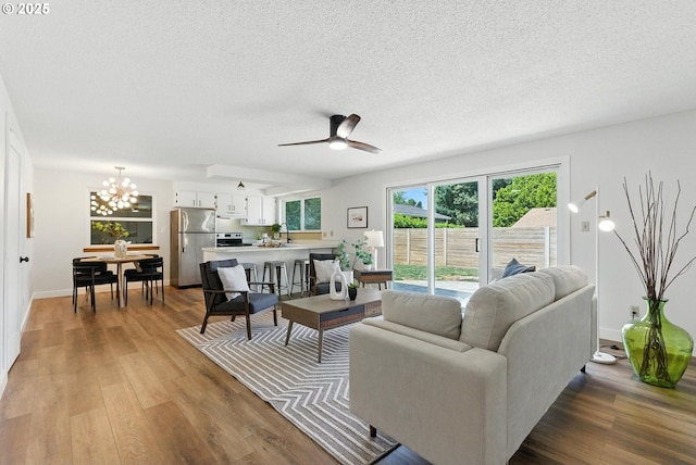 7631 SE Thompson Rd, Milwaukie, OR 97222 - living room with a textured ceiling, wood finished floors, a chandelier, and ceiling fan