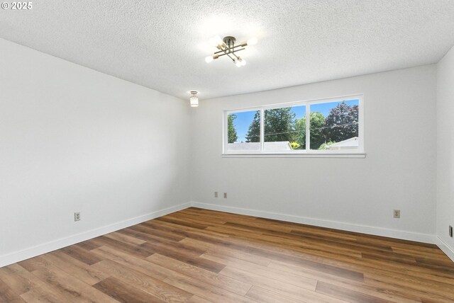 7631 SE Thompson Rd, Milwaukie, OR 97222 - empty room featuring wood finished floors and a textured ceiling