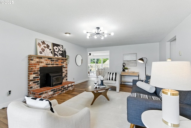 7631 SE Thompson Rd, Milwaukie, OR 97222 - living area with a wood stove, wood finished floors, a chandelier, and a textured ceiling