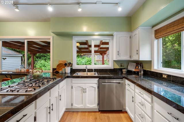 6116 SE 36th Ave, Portland, OR 97202 - kitchen featuring appliances with stainless steel finishes, tile countertops, a sink, track lighting, and white cabinets