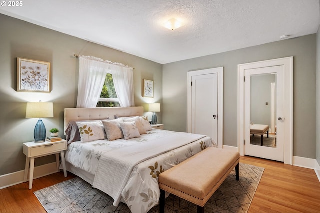 6116 SE 36th Ave, Portland, OR 97202 - bedroom featuring light wood-type flooring, baseboards, and a textured ceiling