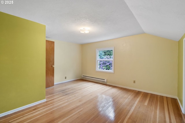 6116 SE 36th Ave, Portland, OR 97202 - spare room with baseboard heating, light wood-type flooring, baseboards, lofted ceiling, and a textured ceiling
