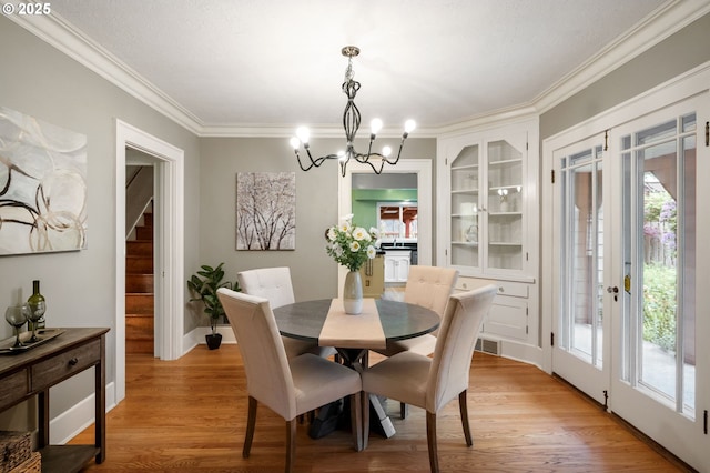 6116 SE 36th Ave, Portland, OR 97202 - dining room featuring crown molding, healthy amount of natural light, light wood-style flooring, a chandelier, and baseboards