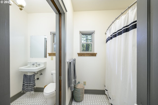 bathroom featuring curtained shower and toilet