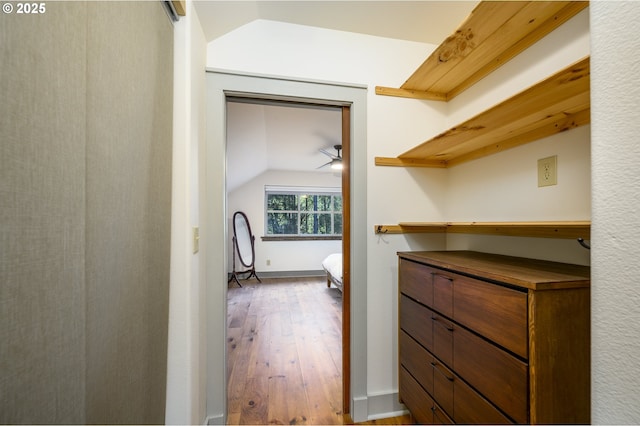 spacious closet featuring hardwood / wood-style flooring and vaulted ceiling