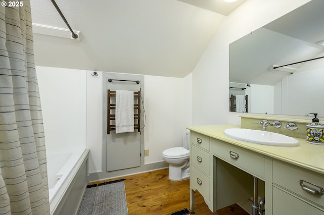 full bathroom featuring hardwood / wood-style flooring, vanity, shower / bath combination with curtain, vaulted ceiling, and toilet