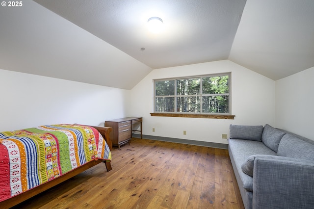 bedroom featuring lofted ceiling and hardwood / wood-style flooring