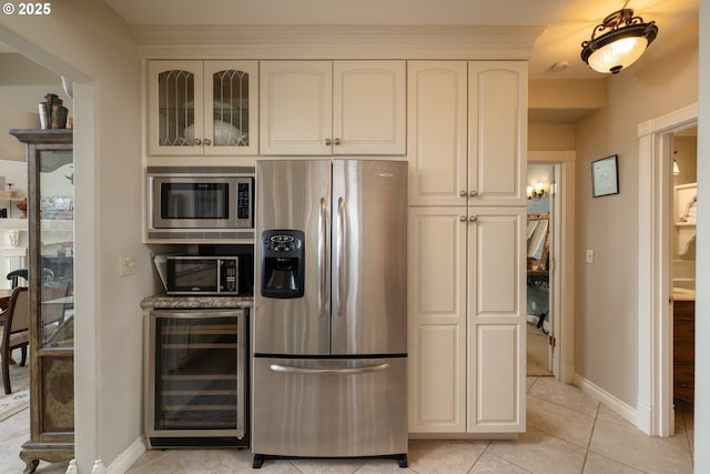 kitchen with white cabinetry, appliances with stainless steel finishes, beverage cooler, and light tile patterned floors