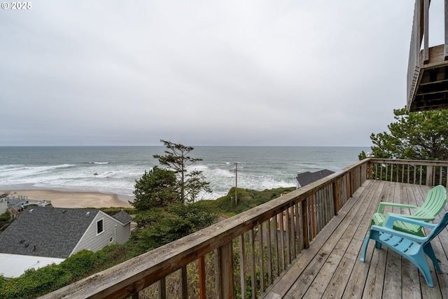 wooden deck with a water view and a beach view