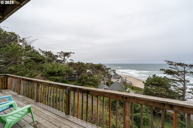 wooden terrace with a water view and a view of the beach