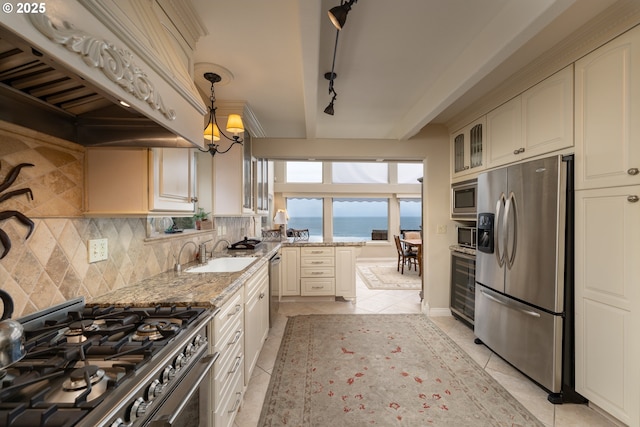 kitchen with sink, custom exhaust hood, a water view, stainless steel appliances, and light stone countertops