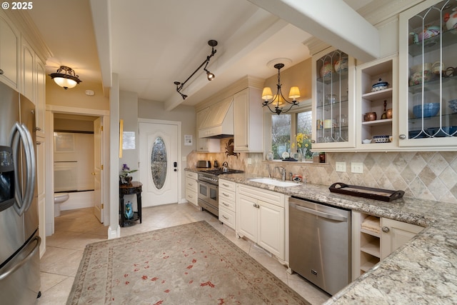 kitchen featuring sink, stainless steel appliances, light stone countertops, decorative backsplash, and decorative light fixtures