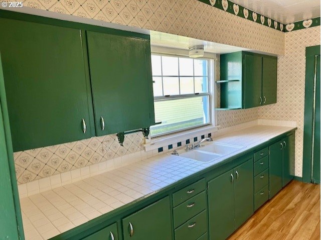 1413 Union Ave, North Bend, OR 97459 - kitchen featuring a sink, light wood finished floors, green cabinetry, and wallpapered walls