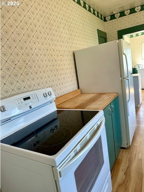 1413 Union Ave, North Bend, OR 97459 - kitchen with white electric range oven, light wood-style flooring, and wallpapered walls
