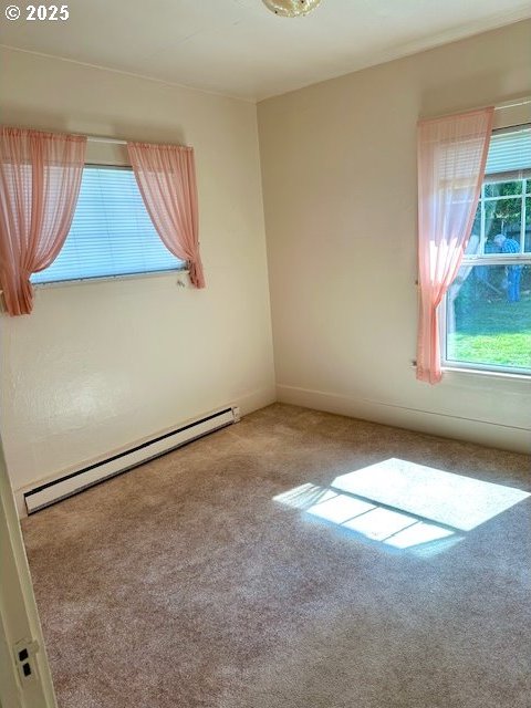 1413 Union Ave, North Bend, OR 97459 - unfurnished room featuring a baseboard heating unit, carpet flooring, and plenty of natural light