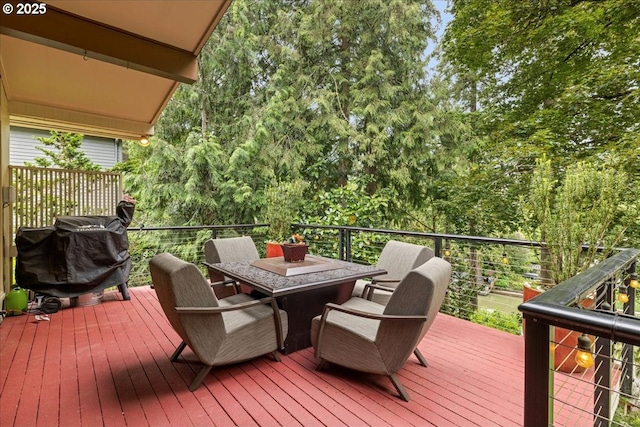 wooden terrace featuring a grill and outdoor dining space