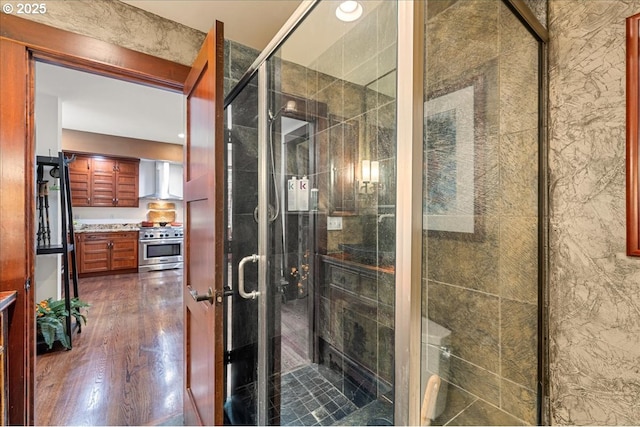 bathroom with wood finished floors and a stall shower