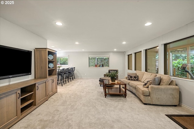 living area with recessed lighting, light carpet, and baseboards