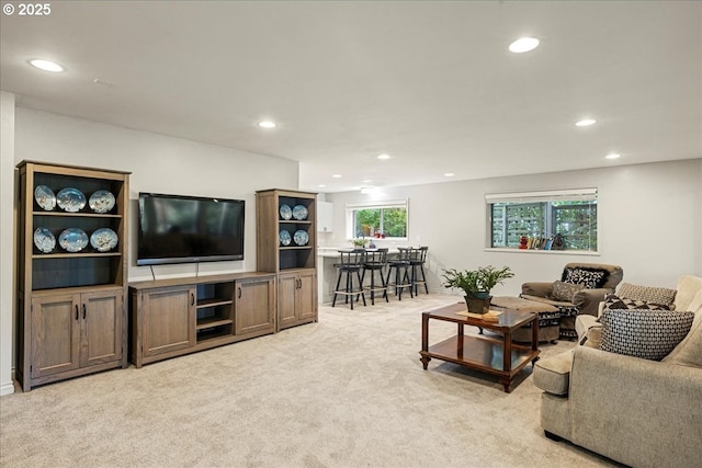 living area with recessed lighting and light carpet