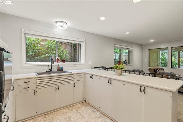 kitchen featuring a sink, healthy amount of natural light, light countertops, and recessed lighting