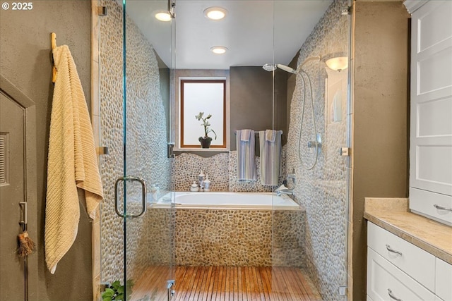 full bathroom with wood finished floors, a shower stall, and a garden tub
