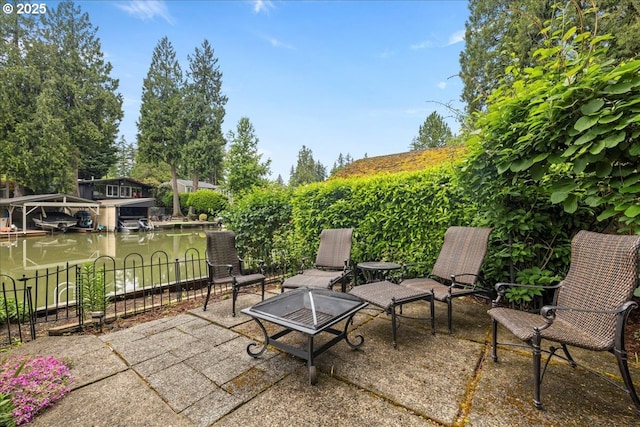 view of patio featuring fence and a dock