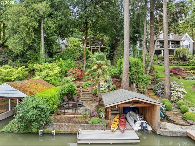 view of property's community with a floating dock, view of wooded area, and a water view