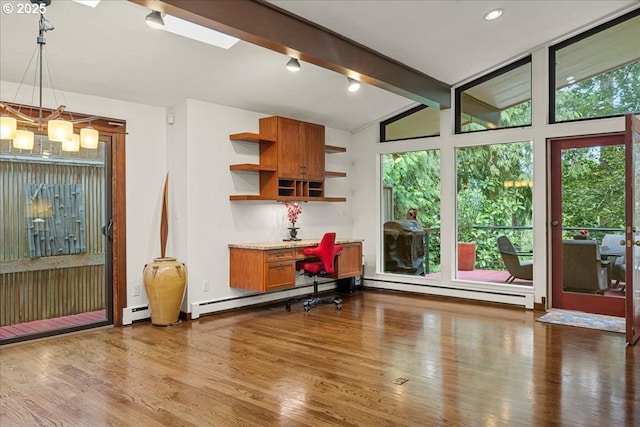 dining area featuring a baseboard radiator, healthy amount of natural light, and wood finished floors