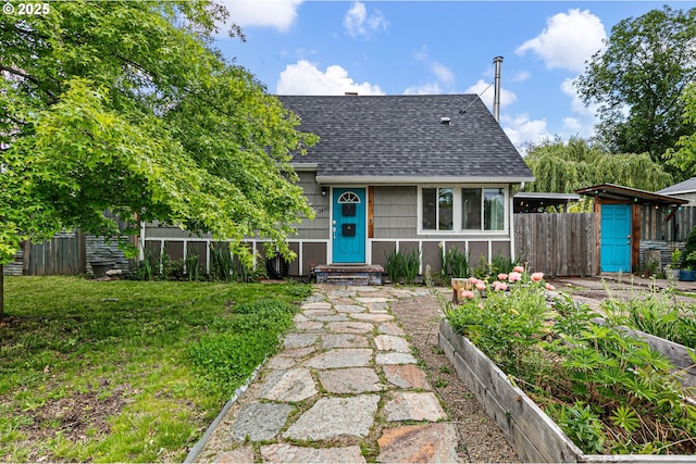 view of front of home with roof with shingles and a garden