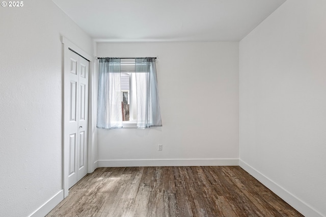 unfurnished room featuring wood finished floors and baseboards