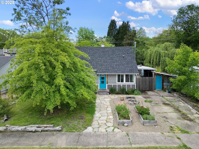 view of front of property featuring a shingled roof and fence