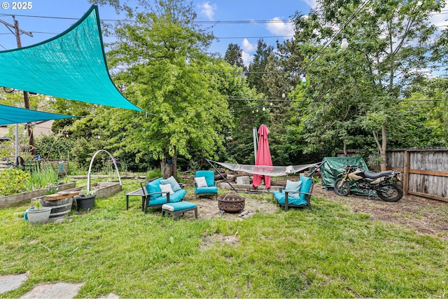 view of yard with a garden and an outdoor fire pit
