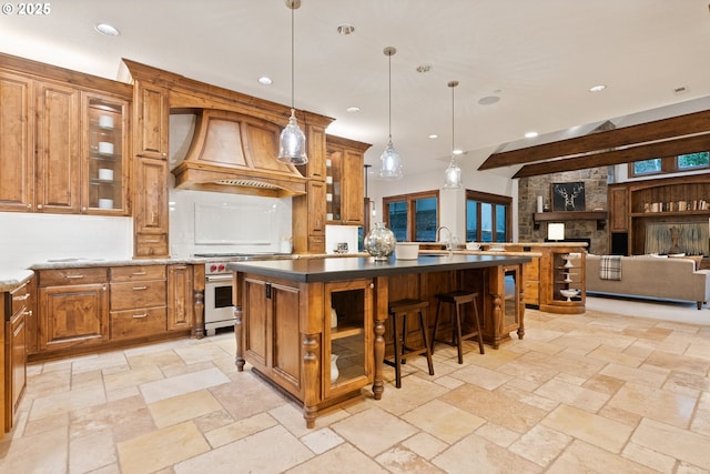 kitchen with high end range, custom exhaust hood, a center island, hanging light fixtures, and a breakfast bar area