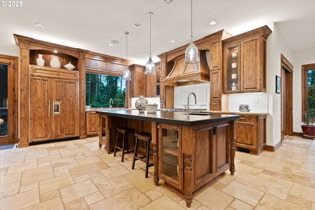 bar featuring backsplash, decorative light fixtures, premium range hood, and sink