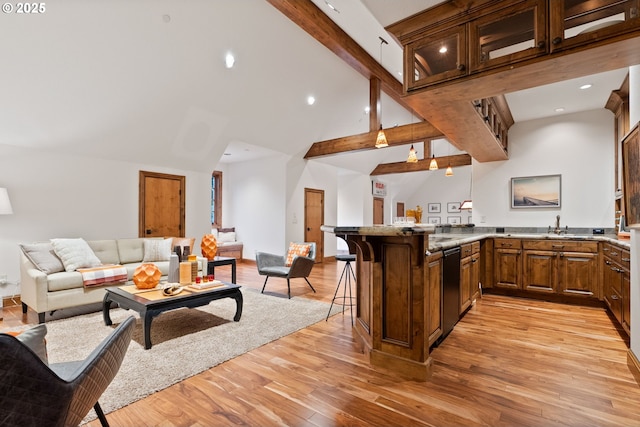 kitchen featuring a breakfast bar, high vaulted ceiling, light hardwood / wood-style flooring, beam ceiling, and kitchen peninsula