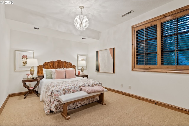 carpeted bedroom featuring a notable chandelier