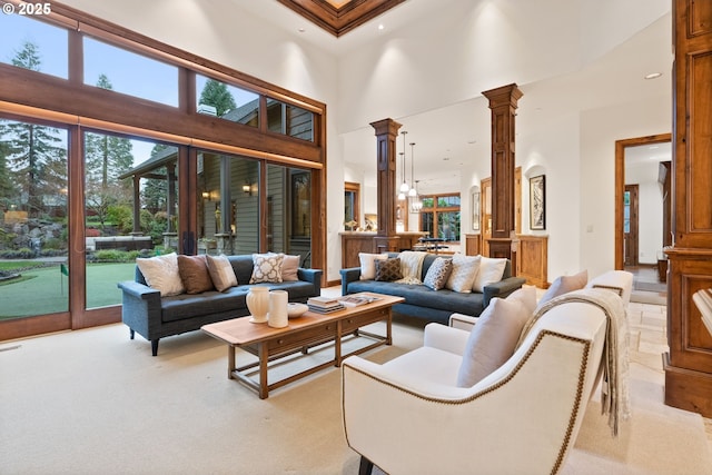 living room featuring decorative columns, light carpet, crown molding, and a high ceiling