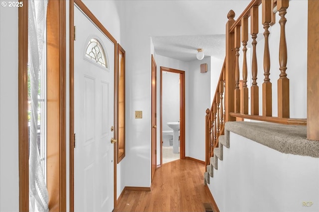 5868 NW Landing Dr, Portland, OR 97210 - entryway with light wood finished floors, stairway, and baseboards