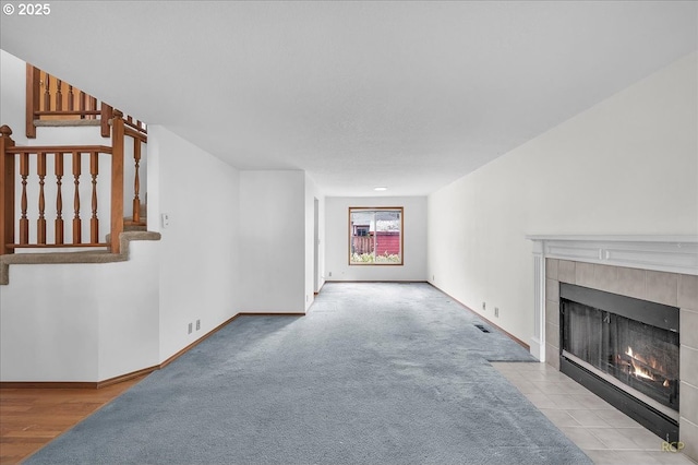 5868 NW Landing Dr, Portland, OR 97210 - unfurnished living room with a fireplace, stairs, baseboards, and carpet