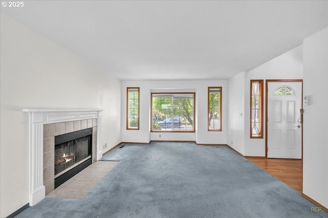 5868 NW Landing Dr, Portland, OR 97210 - unfurnished living room with carpet floors, a tiled fireplace, and baseboards