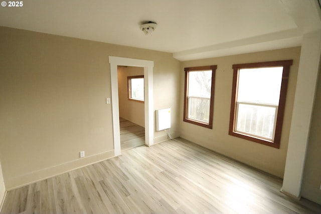 unfurnished room with baseboards and light wood-style floors