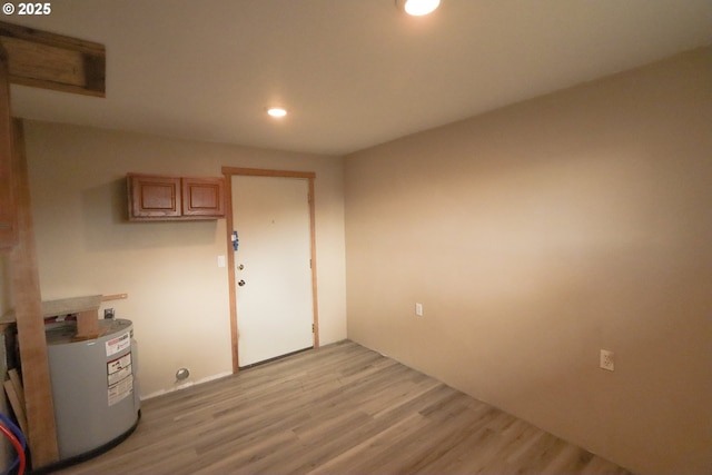 interior space featuring recessed lighting, electric water heater, and light wood finished floors