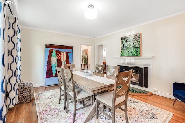 6209 SE 13th Ave, Portland, OR 97202 - dining room with ornamental molding, wood finished floors, a glass covered fireplace, and baseboards