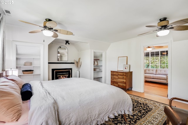 6209 SE 13th Ave, Portland, OR 97202 - bedroom with light wood finished floors, a glass covered fireplace, ceiling fan, and crown molding