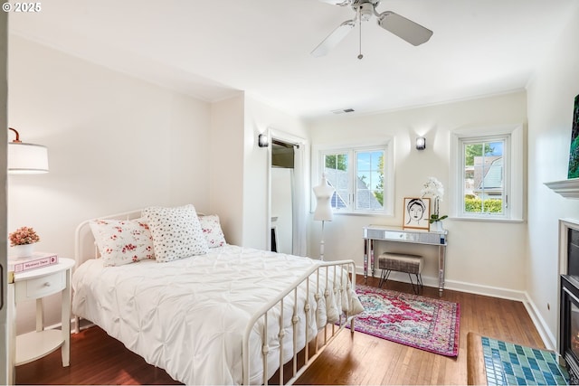 6209 SE 13th Ave, Portland, OR 97202 - bedroom featuring wood finished floors, a fireplace with flush hearth, baseboards, and ceiling fan