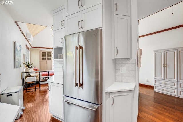 6209 SE 13th Ave, Portland, OR 97202 - kitchen featuring high end refrigerator, hardwood / wood-style flooring, decorative backsplash, vaulted ceiling, and an AC wall unit