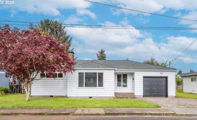 view of front of property with a front yard and a garage