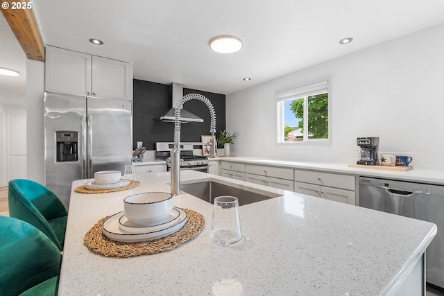 605 SE 104th Ave, Vancouver, WA 98664 - kitchen featuring appliances with stainless steel finishes, light stone countertops, recessed lighting, white cabinets, and wall chimney exhaust hood